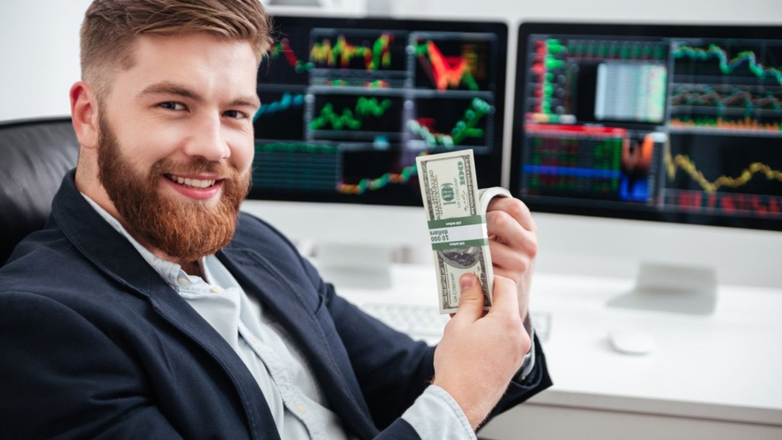 a man smiling while holding money with the background of forex trading showing wealth in the forex market